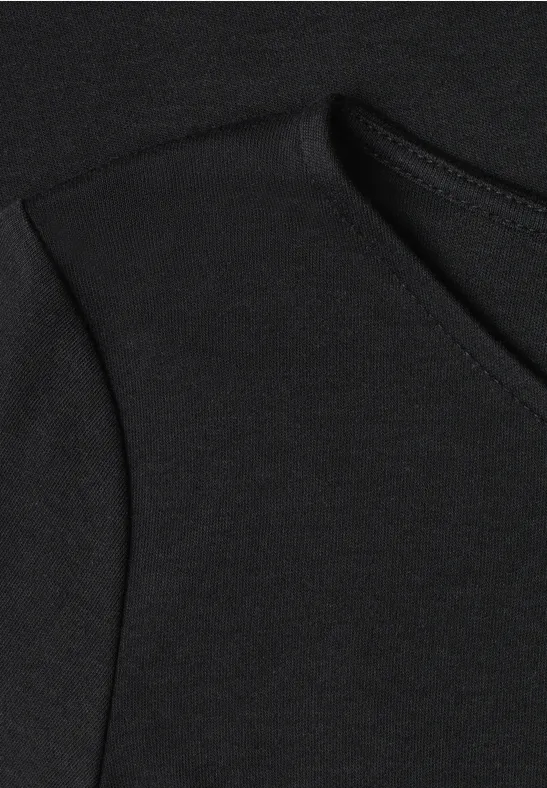 Nahaufnahme eines schwarzen Kleidungsstücks mit Tasche und sichtbarer Naht