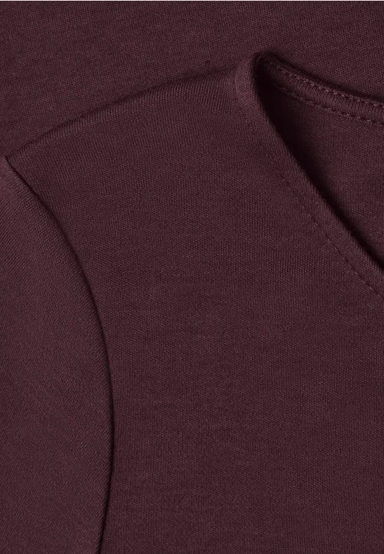 Nahaufnahme eines burgunderfarbenen Pullover-Ausschnitts.