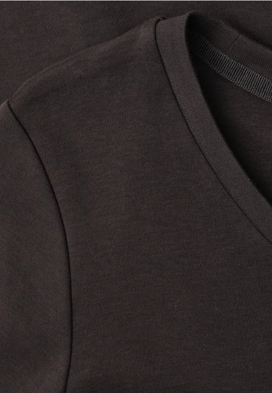 Nahaufnahme eines schwarzen V-Ausschnitt-T-Shirts aus Baumwollstoff mit feiner Naht an Schulter und Halsbündchen.
