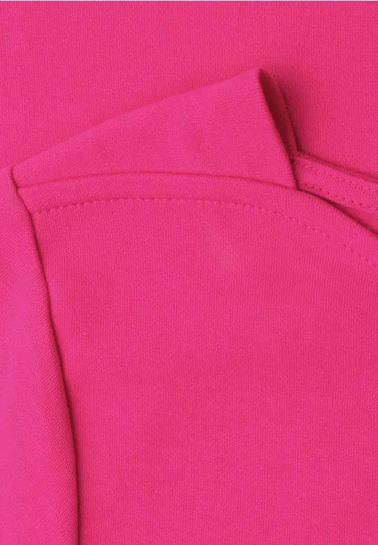 Nahaufnahme eines pinken T-Shirts mit Schulter- und Halsausschnittnaht.