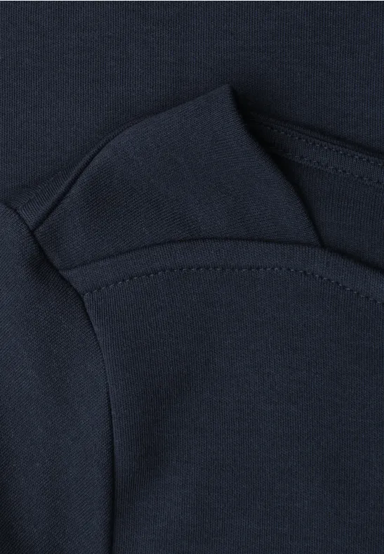 Dunkelblauer Baby-Body mit weichem Baumwollstoff, Umschlagärmeln und rundem Halsausschnitt.