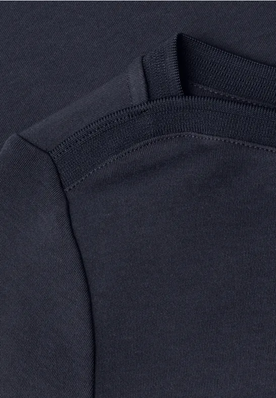 Zbliżenie na ciemnoniebieski t-shirt z widocznym szwem na ramieniu i rękawie.