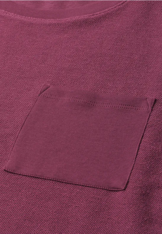 Un t-shirt violet uni avec poche plaquée sur la poitrine.