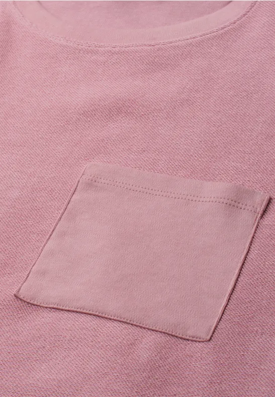 Różowy t-shirt z naszywaną kieszonką na piersi z miękkiego materiału.