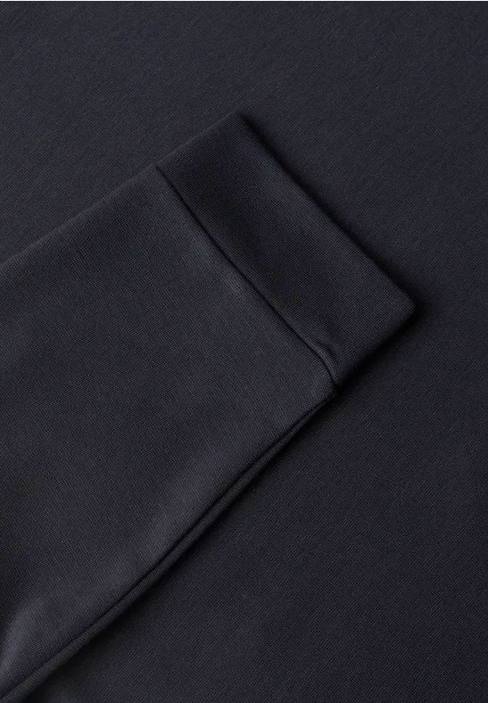 Nahaufnahme eines schwarzen Sweatshirtärmels mit elastischer Bündchenstruktur.