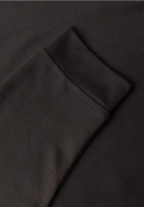 Schwarzer Stoff mit aufgesetzter Tasche und Bündchen, vermutlich ein Sweatshirt.