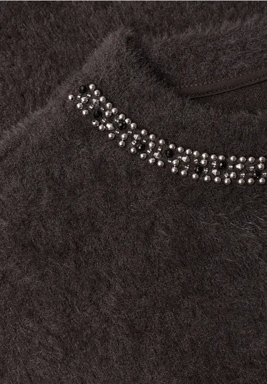 Dunkler, flauschiger Pullover mit silbernen Nieten am Kragen.