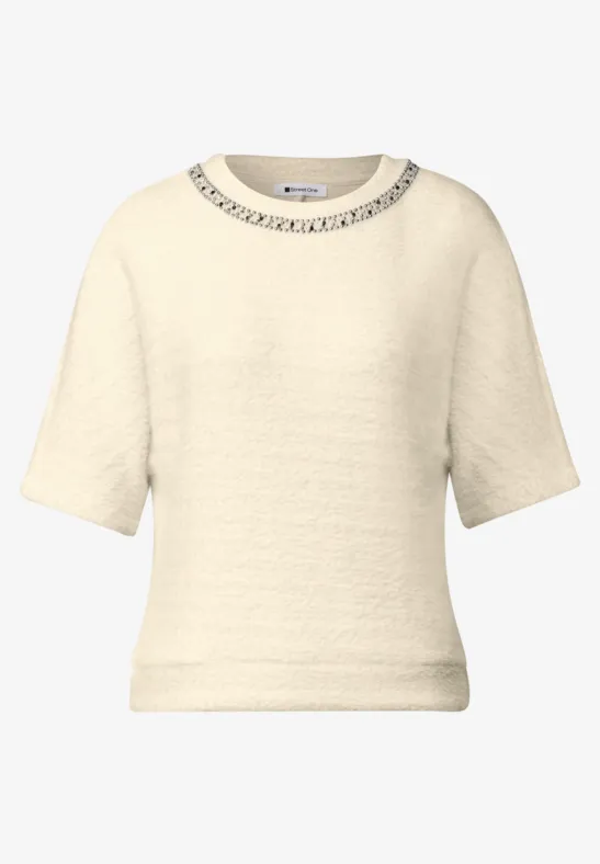 Cremefarbener kurzärmliger Pullover mit feiner Struktur und Rundhalsausschnitt.