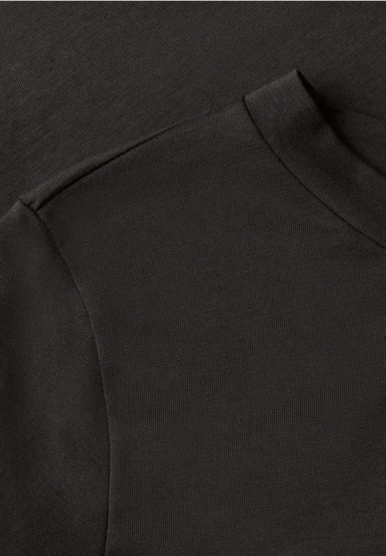 Nahaufnahme eines schwarzen T-Shirts mit Rundhalsausschnitt und Schulternaht.