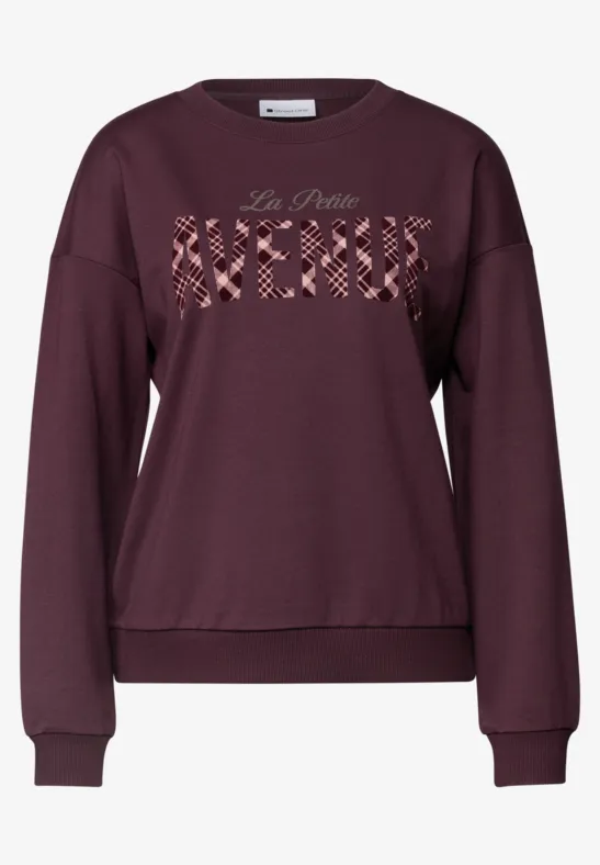 Ein weinrotes Sweatshirt mit Rundhalsausschnitt und 'La Petite Merci' auf der Brust.
