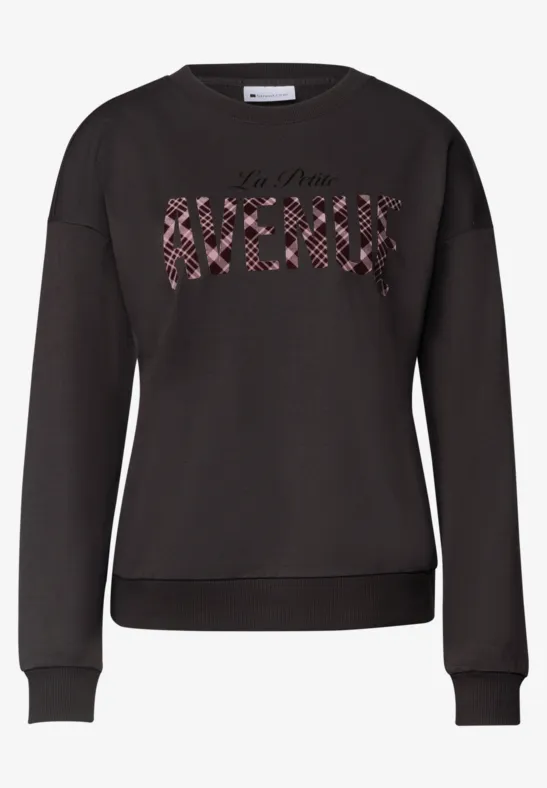Schwarzer Sweater mit Rundhalsausschnitt und Frontschriftzug "AVENUE" in rot geblümtem Muster.