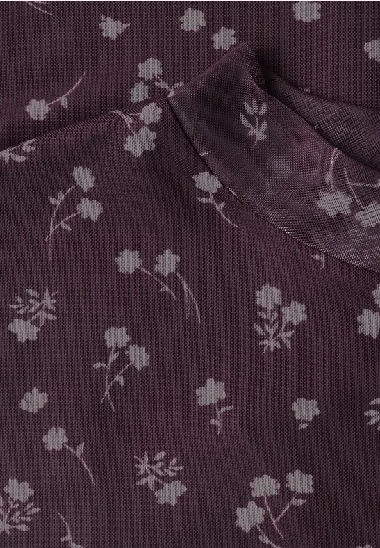 Lila Stoff mit zarten weißen Blumenprints und angedeutetem Stehkragen.