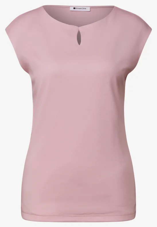 Un débardeur femme rose pâle à encolure ronde avec petite ouverture.