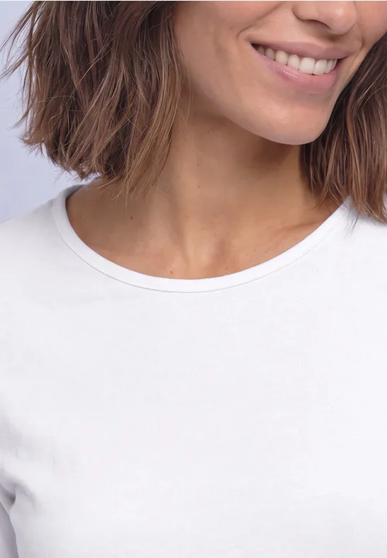 Close-up van een glimlachende vrouw met kort bruin haar in een wit t-shirt.