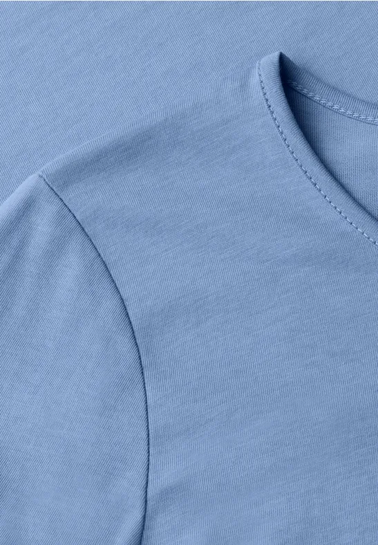 Close-up van een lichtblauw T-shirt met ronde hals.