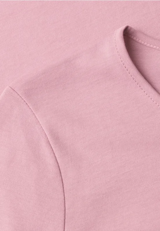 Detailaufnahme eines hellrosa T-Shirts mit Rundhalsausschnitt und Schulternaht.