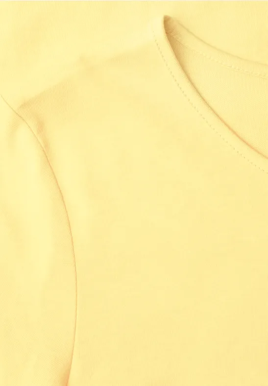 Helles gelbes T-Shirt, Nahaufnahme von Kragen und Schulterbereich.