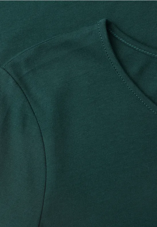Detailaufnahme eines dunkelgrünen, kurzärmligen T-Shirts aus weichem Stoff.