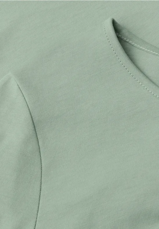 Close-up van een lichtgroen shirt met ronde hals en korte mouw