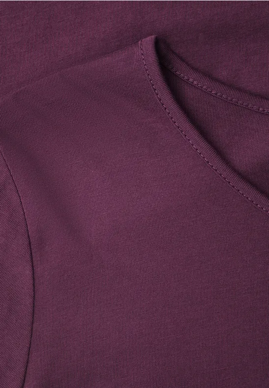 Nahaufnahme eines violetten T-Shirts am Halsausschnitt.