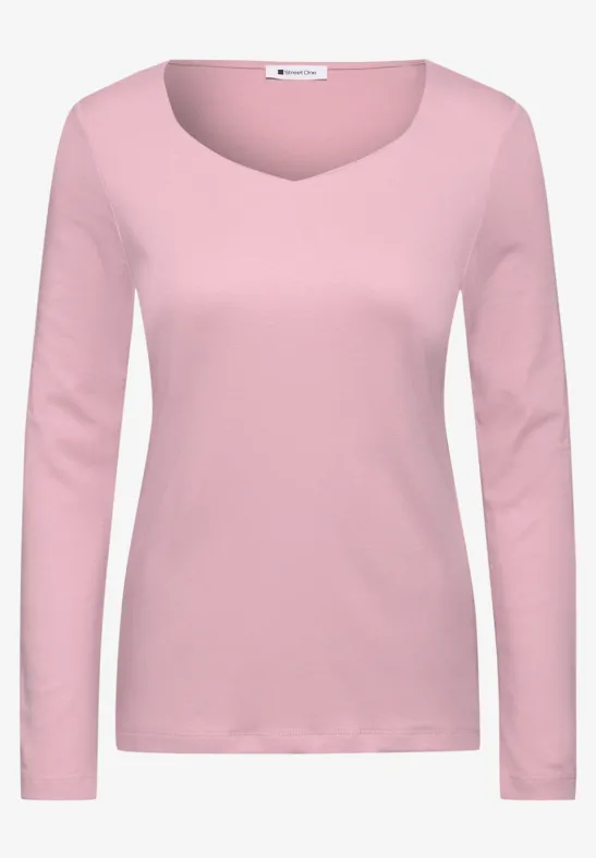 Een eenvoudig damesshirt in roze met lange mouwen en ronde hals.