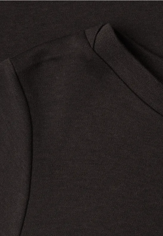 Nahaufnahme eines schwarzen T-Shirts mit Schulter- und Kragennaht.