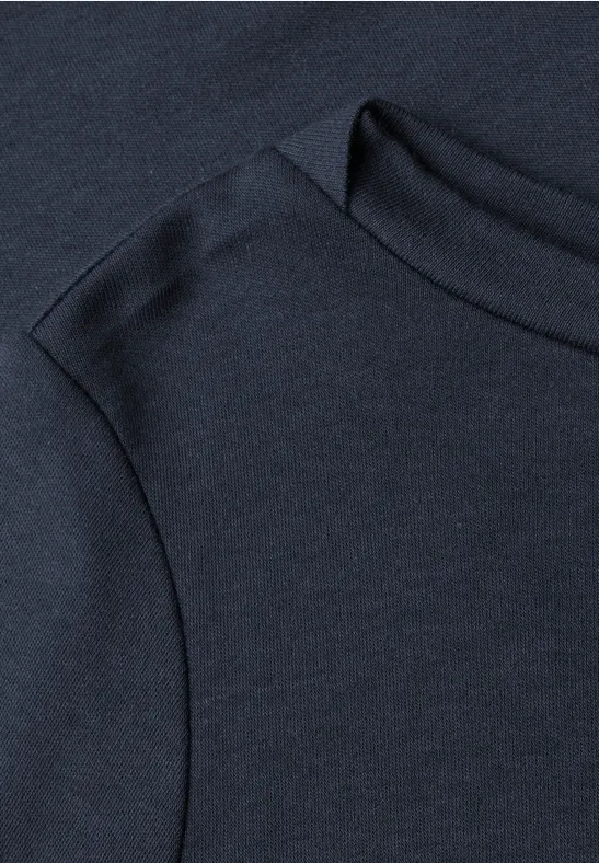 Zbliżenie na granatowy t-shirt z widocznym szwem na ramieniu i przy kołnierzu