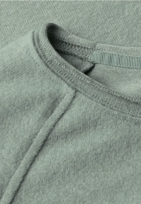 Nahaufnahme eines mintgrünen Shirts mit Rundhalsausschnitt und sichtbarer Naht.