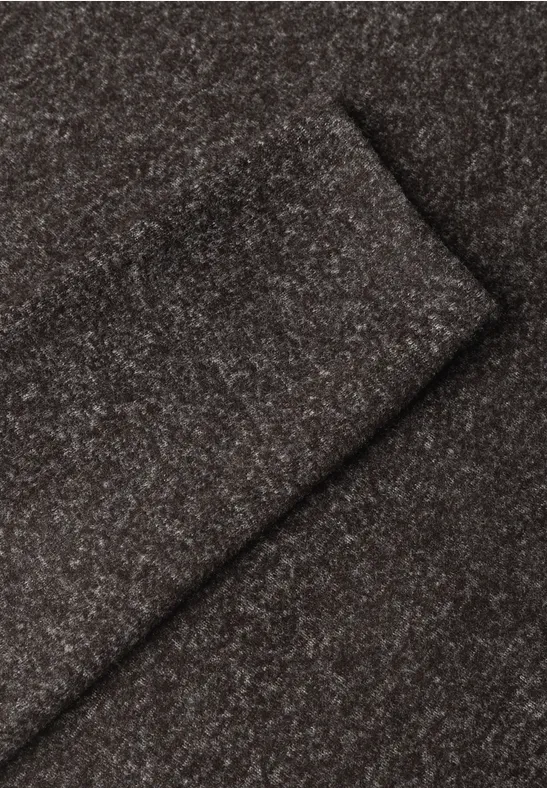 Close-up van een zachte, bruine wollen stof met fijne melering en diagonale plooien.