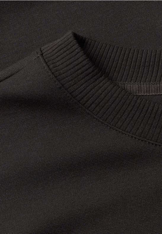 Schwarzer Pullover mit geripptem Rundhalsausschnitt.