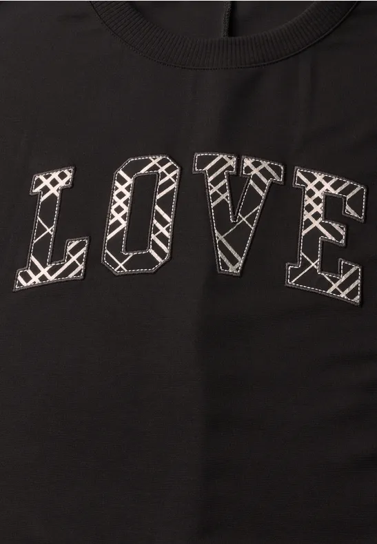 Schwarzes T-Shirt mit dem Aufdruck 'LOVE' in weißer, grafischer Buchstabenoptik.