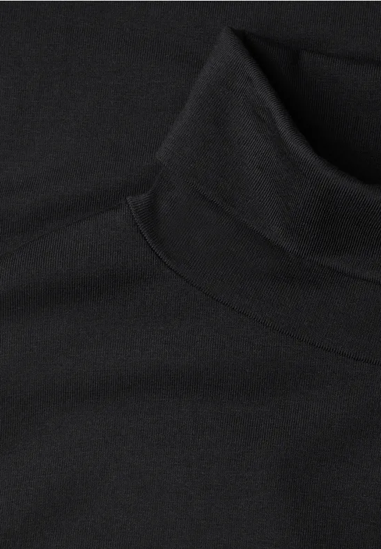 Schwarzer Rollkragenpullover aus weichem Stoff, Nahaufnahme.