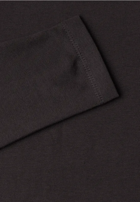 Schwarzer Stoff eines Langarmshirts mit sichtbarer Naht am Ärmelabschluss.