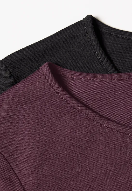 Zwei Rundhals-T-Shirts, eines in Schwarz, eines in Aubergine, nebeneinander angeordnet.
