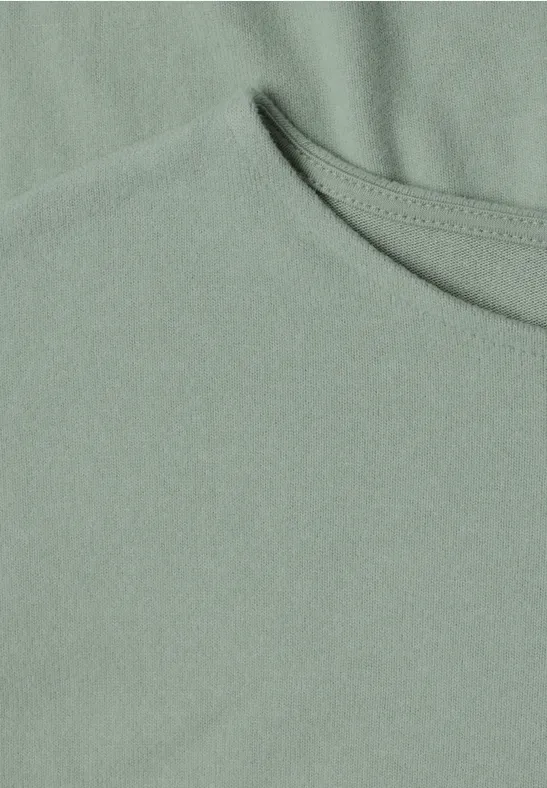 Nahaufnahme eines hellgrünen T-Shirts mit Rundhalsausschnitt und feiner Stoffstruktur.