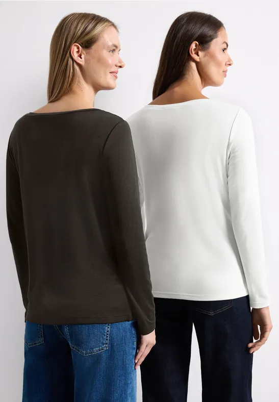 Zwei Frauen von hinten in schlichten Langarmshirts in Weiß und Dunkelgrün vor weißem Hintergrund.