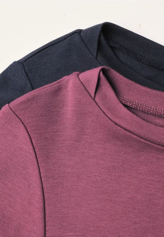 Zwei schlichte Shirtkragen in Marineblau und Lila auf hellem Hintergrund