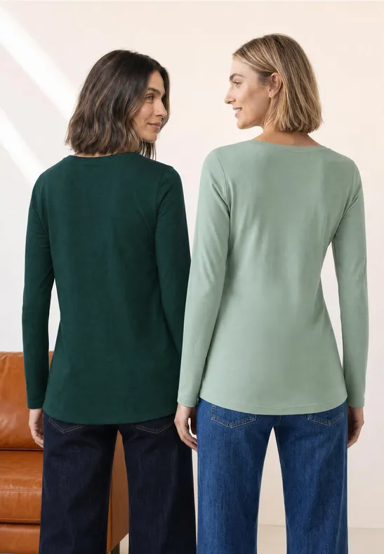 Twee vrouwen van achteren in jeans en tops met lange mouwen in verschillende groentinten.