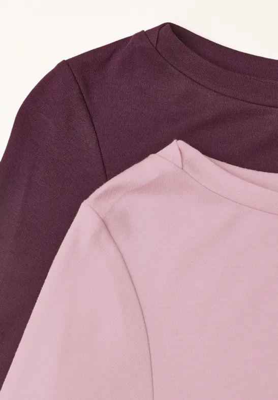 Zwei T-Shirts in Rosé und Weinrot auf einem weißen Hintergrund