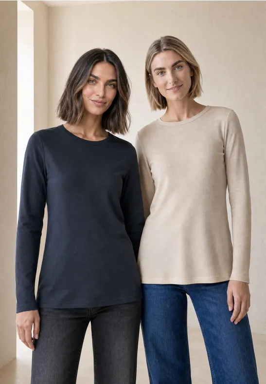 Twee lachende vrouwen in eenvoudige lange mouwtopjes (marineblauw en beige) staan naast elkaar.