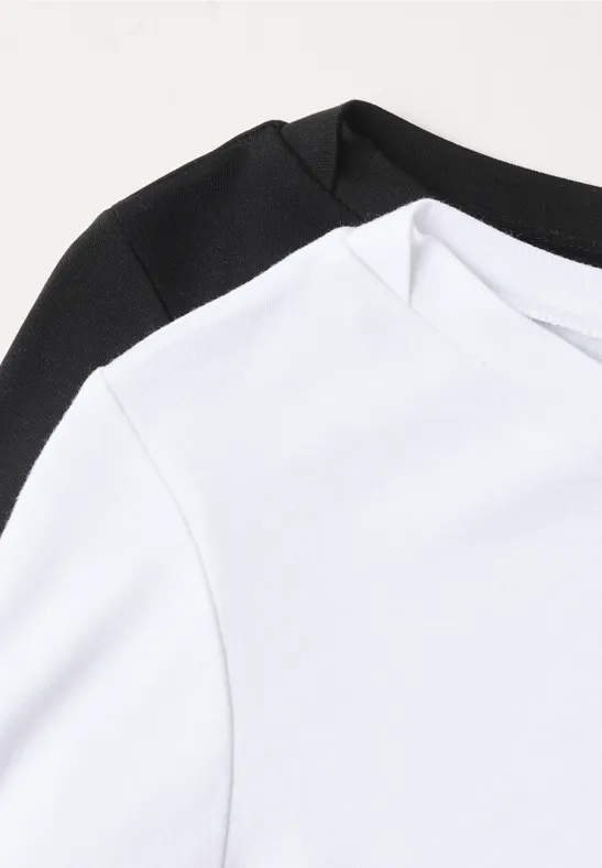 Zwei schlichte T-Shirts, eines weiß, eines schwarz, Nahaufnahme mit minimalistischem Design.
