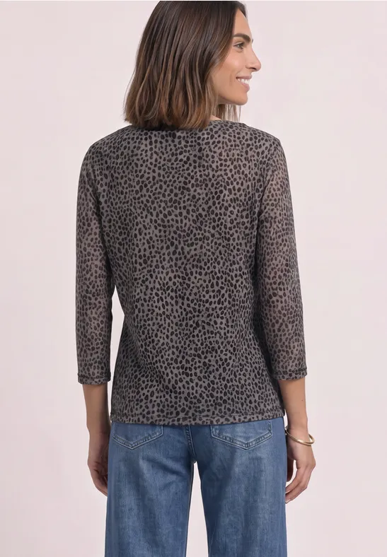 Frau von hinten in Jeans und 3/4-Arm Shirt mit dezentem Leopardenmuster.