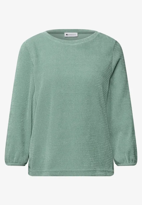 Hellgrüner Pullover mit feinem Strickmuster und lockerer Passform.