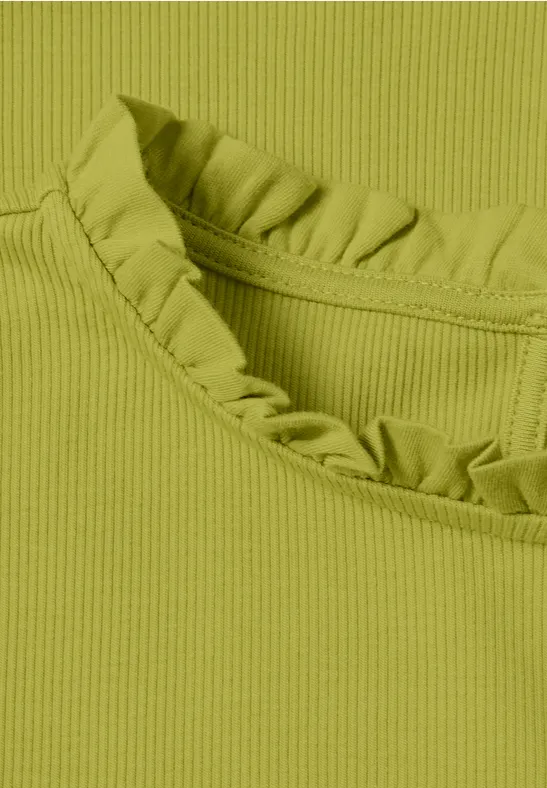 Close-up van een ribbeltricot top in olijfgroen met ruches bij de ronde hals.