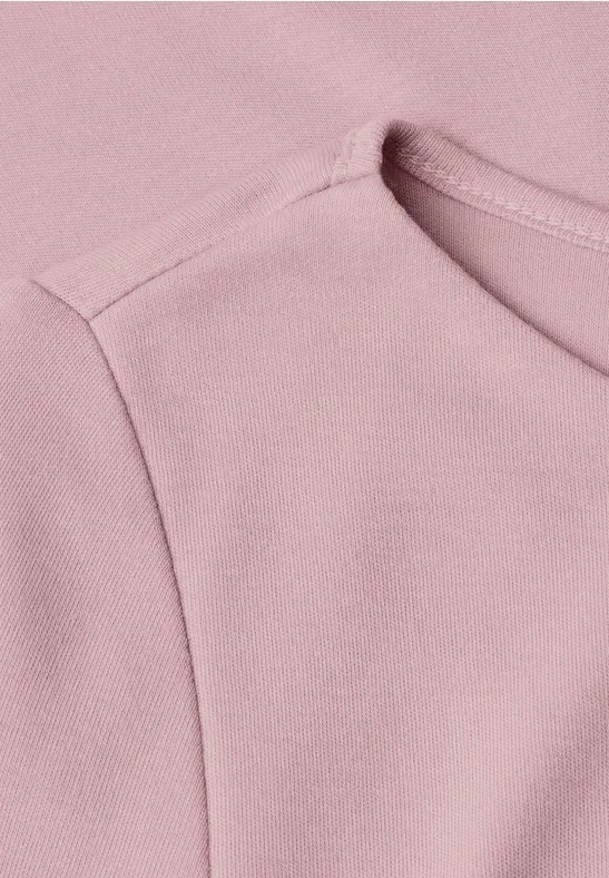 Nahaufnahme eines rosa Shirts mit sichtbarer Schulternaht und Rundhalsausschnitt.