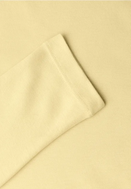 Gros plan d’un tissu jaune clair avec une couture apparente