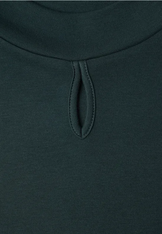 Haut vert foncé à col rond et petite découpe en forme de goutte sous le col.