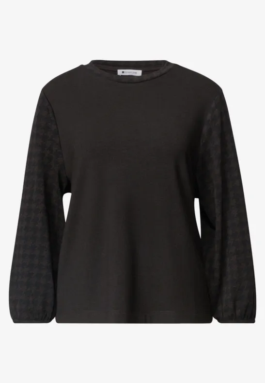 Schwarzes Langarmshirt mit leicht ballonförmigen Ärmeln und dezent geometrischem Muster