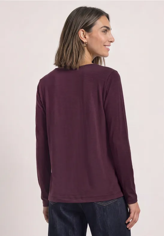 Dames top aubergine met lange mouwen, achterkant zichtbaar.