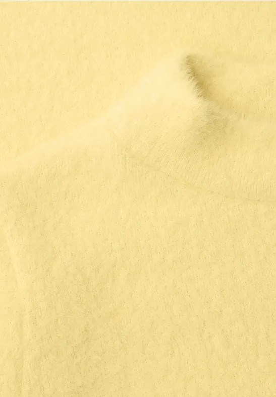 Sanfter, gelber Rollkragenpullover aus weichem, flauschigem Stoff.